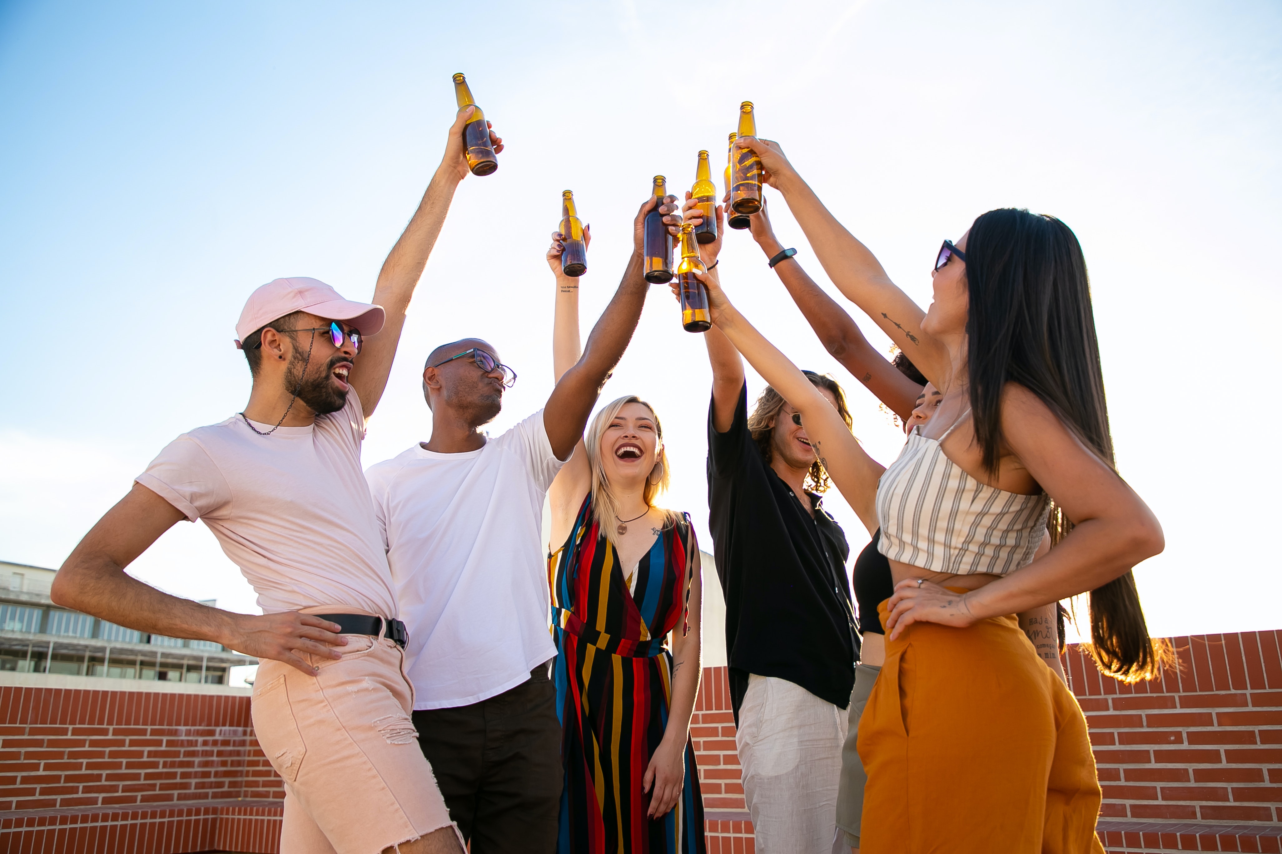 Cinco amigos brindando com bebidas em um rooftop em BH