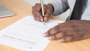 Mão de um homem segurando uma caneta e assinando um documento para ilustrar o artigo um herdeiro pode impedir a venda de um imóvel