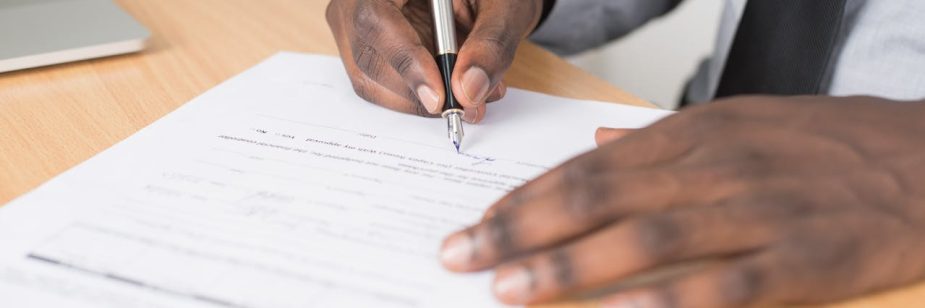 Foto de uma mão assinando uma Procuração para venda de imóvel